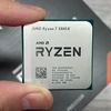 Процессор AMD Ryzen 7 580X в руке, на фоне упаковки.