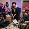 Четыре человека в комнате с компьютерами, радуясь, бросают деньги из сумки.